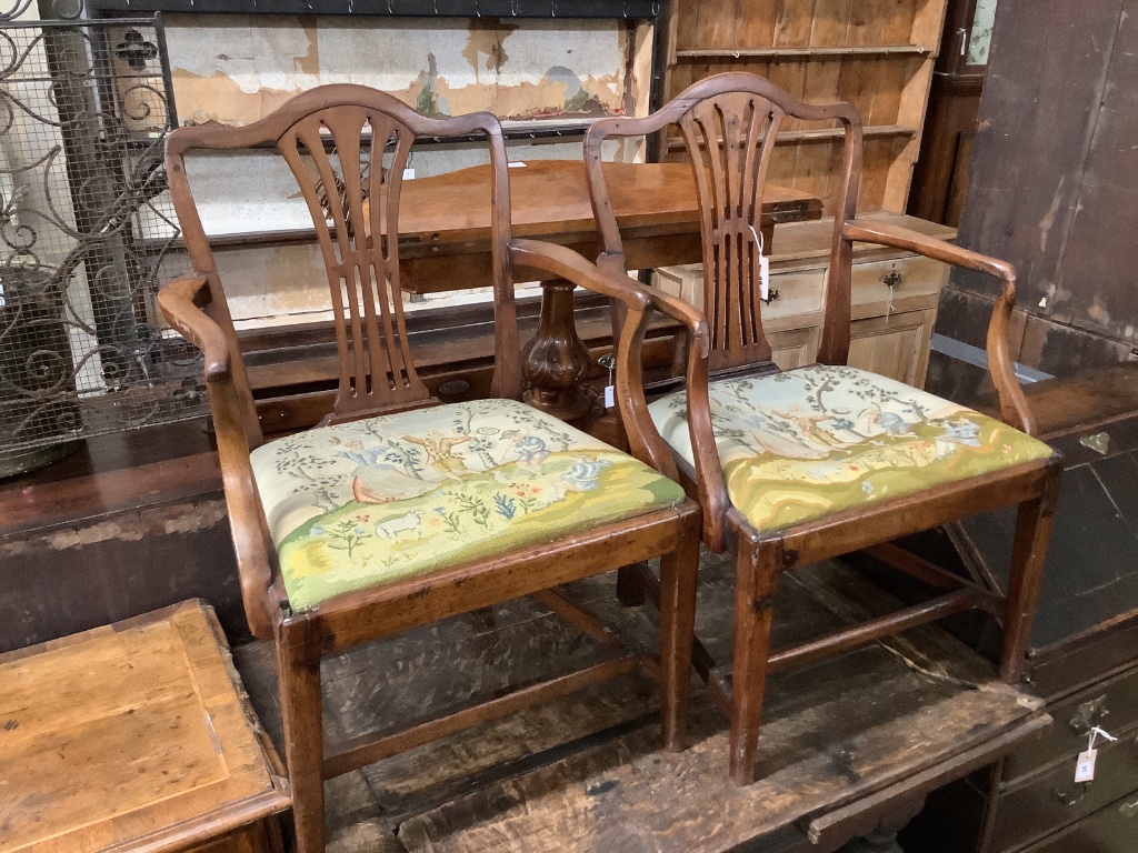 A pair of George III mahogany open elbow chairs